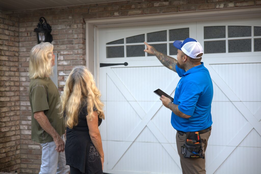 Scott Lundstrom of Lundstrom Home Inspection pointing out exterior maintenance details to homeowners during a residential inspection.