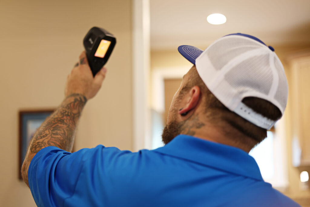 Scott Lundstrom of Lundstrom Home Inspection using a thermal imaging camera to detect moisture or insulation gaps during a home inspection.