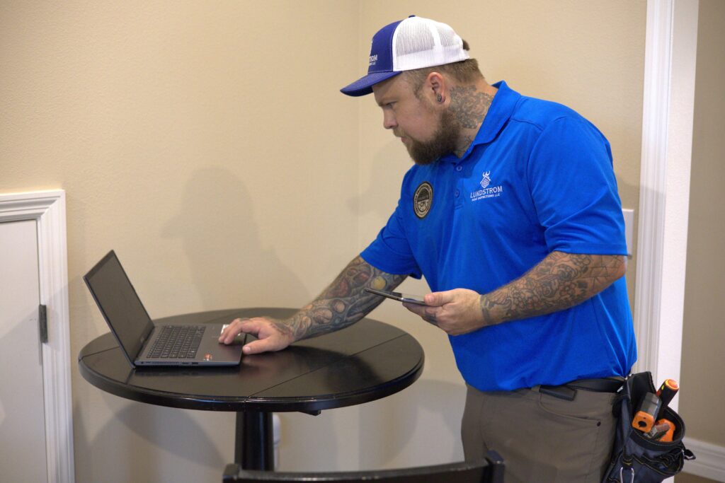 Scott Lundstrom of Lundstrom Home Inspection finalizing a detailed digital property report on a laptop for a client.