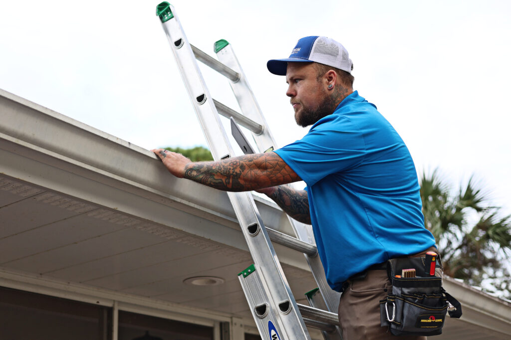 Scott Lundstrom checking gutters and eaves for debris or damage during a comprehensive residential home inspection.