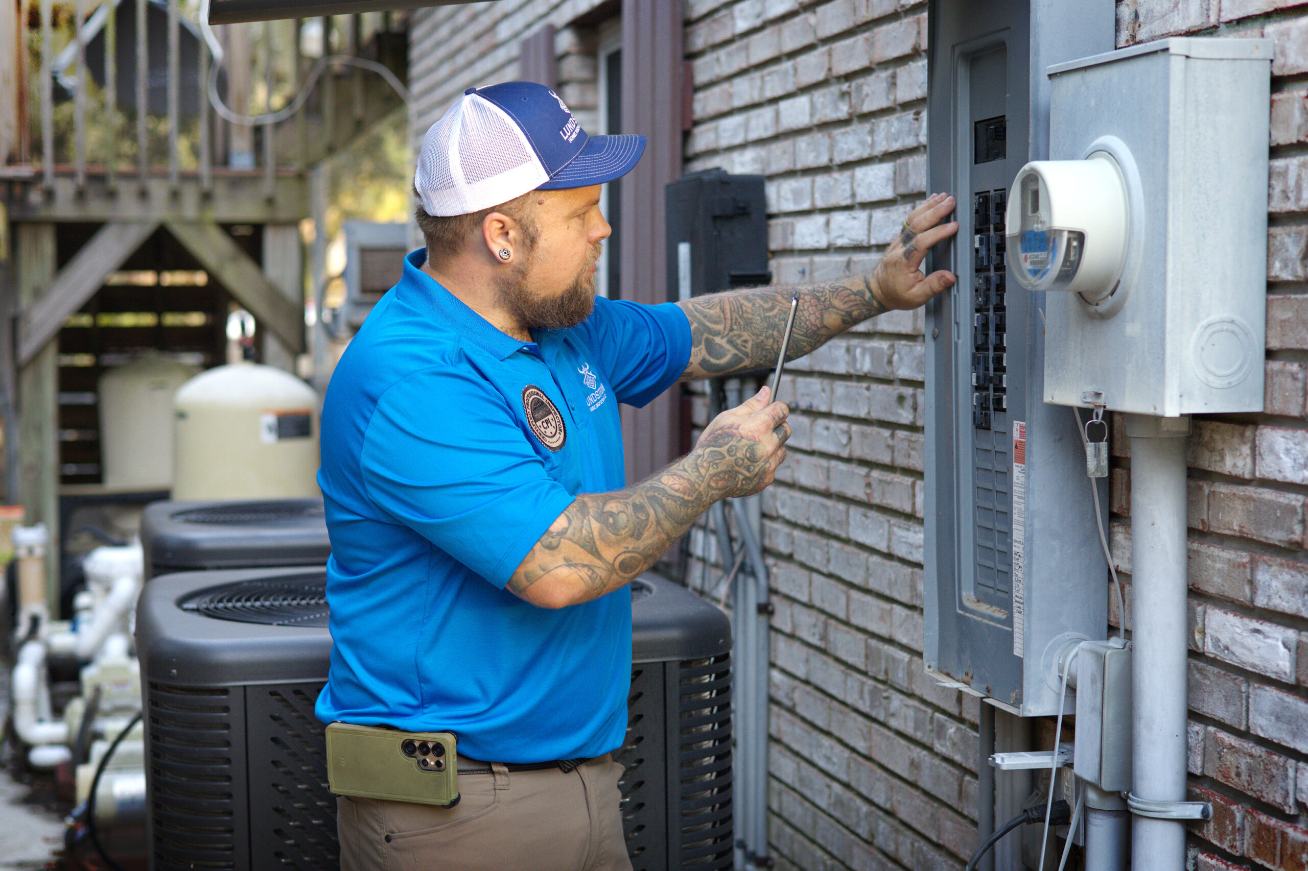 Annual home maintenance inspection by Lundstrom Home Inspections checking exterior electrical panel and service components